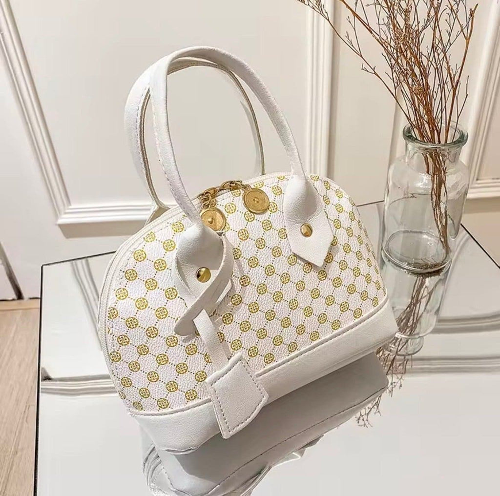 Elegant vit handväska med gyllene mönster