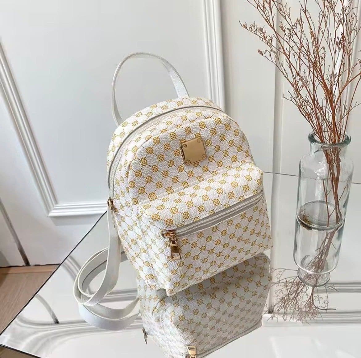 Liten vit och guld ryggsäck med mönster